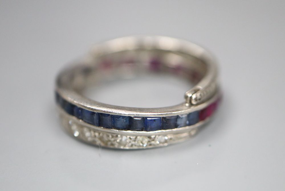 A white metal, diamond, ruby and sapphire swivelling eternity ring (ruby missing), size K, gross 5 grams.